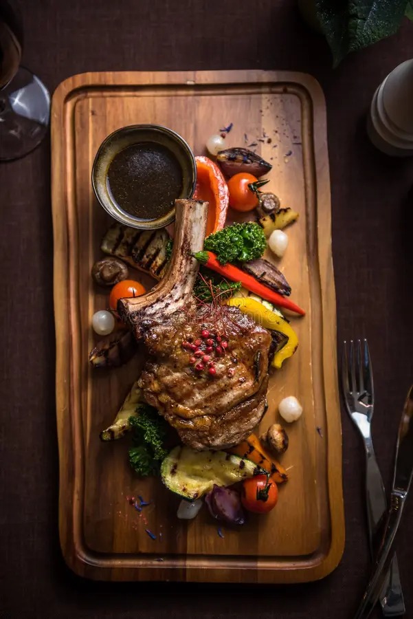 Corte de carne servido con vegetales asados